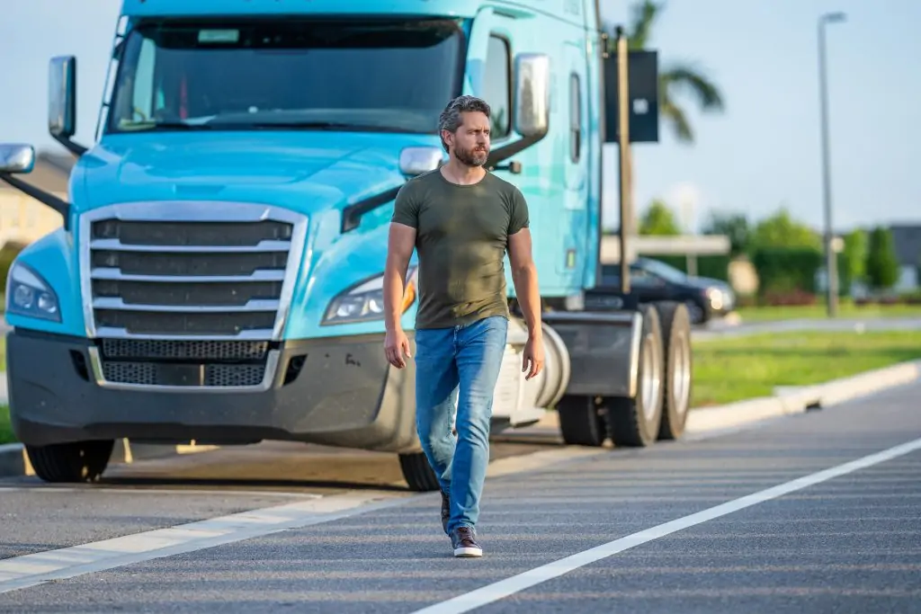 man posing in front of truck. Semi trucks vehicle. man driver near lorry truck.